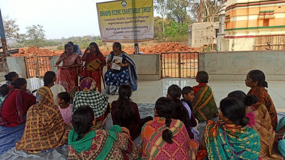 Community members gathered under a Building an Inclusive Community banner in Dumuridihi.