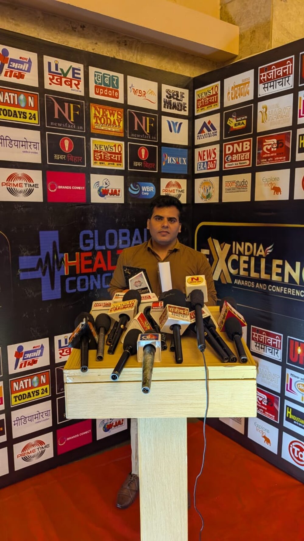Award trophy and recognition wall at the India Excellence Awards 2025.