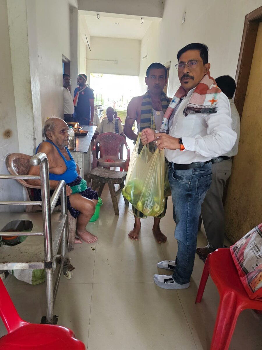 A Brains Iconic Charitable Trust volunteer distributing essentials to an elderly resident.