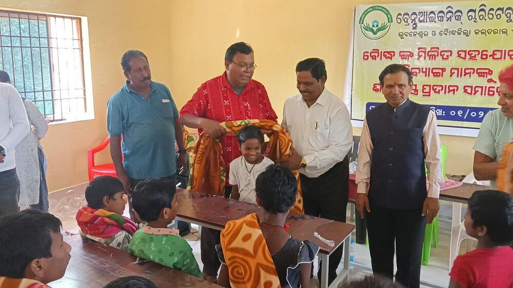 Brains Iconic Charitable Trust volunteers with a group of children at a community distribution event.
