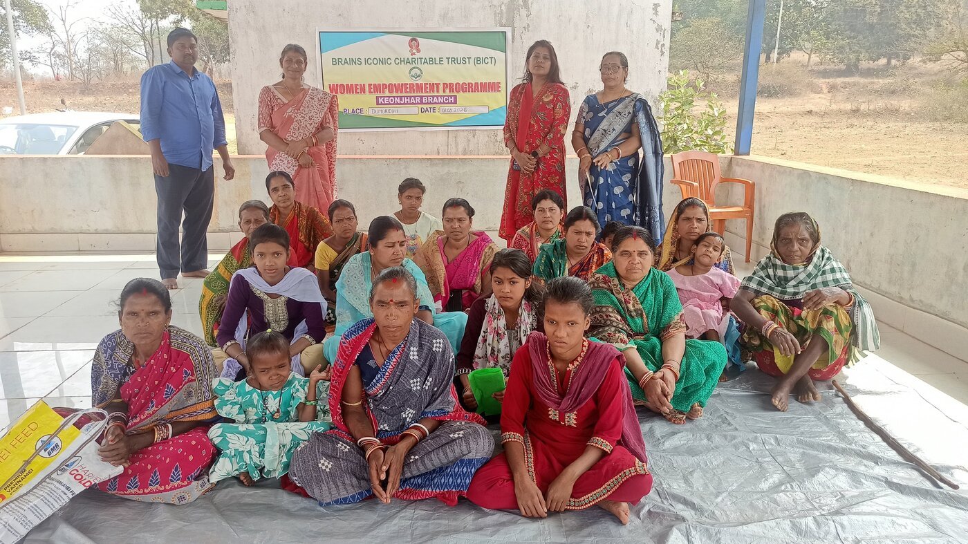 A Women Empowerment Programme session held by Brains Iconic Charitable Trust in Dumuridihi, Keonjhar district, with women and children seated together.